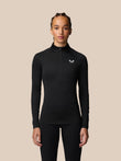 Front view of a woman wearing a black Adapt Training half zip top with a small white logo on the chest