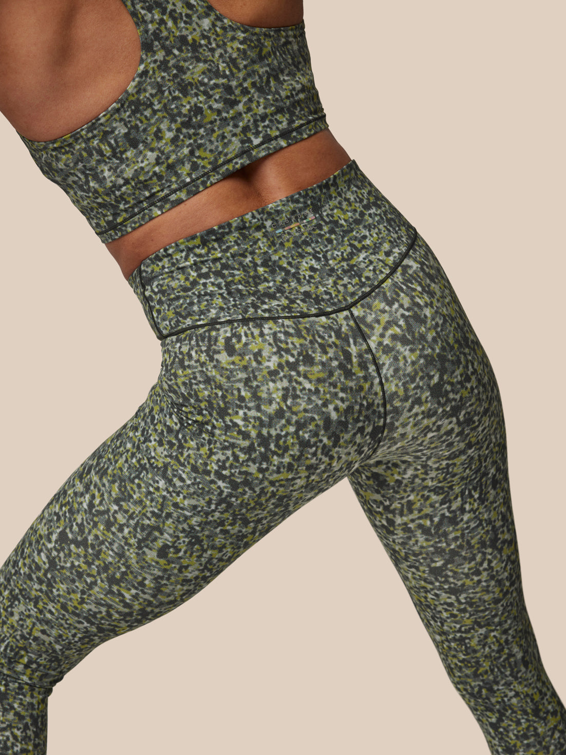 Green camouflage athletic leggings on a neutral background