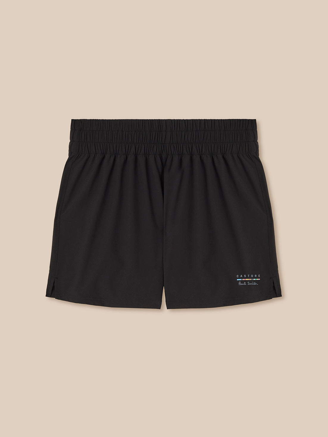 Black shorts with a brand logo on a beige background