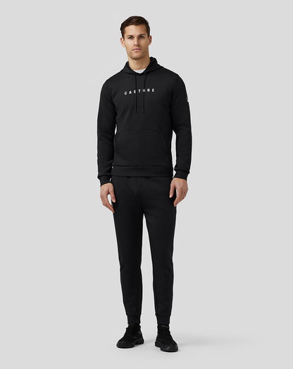 Male model wearing black Castore Flex Hoodie with front logo, drawstring hood and large front pocket.