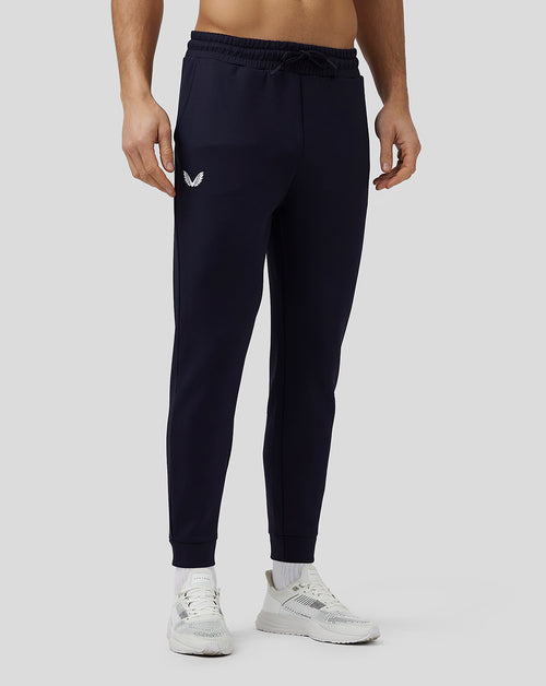 Male model in navy Flex Joggers with side branding and elastic cuffs