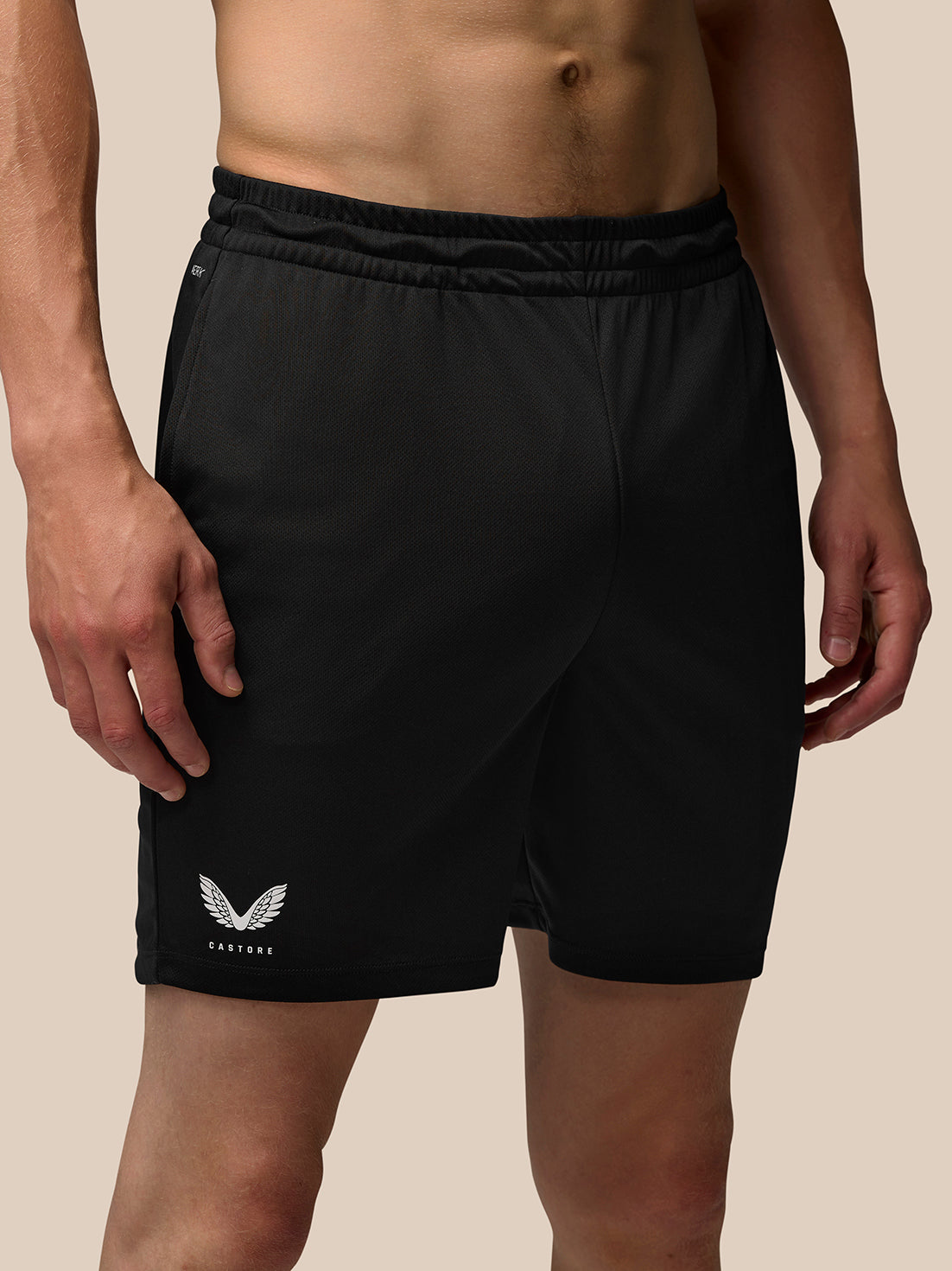 Close up of a man wearing black Adapt Training Shorts with an elastic waistband and Castore branding at the hem.