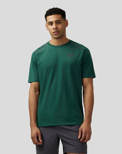 Male model wearing green Men’s Apex Aeromesh T-Shirt with reflective Castore branding on left chest