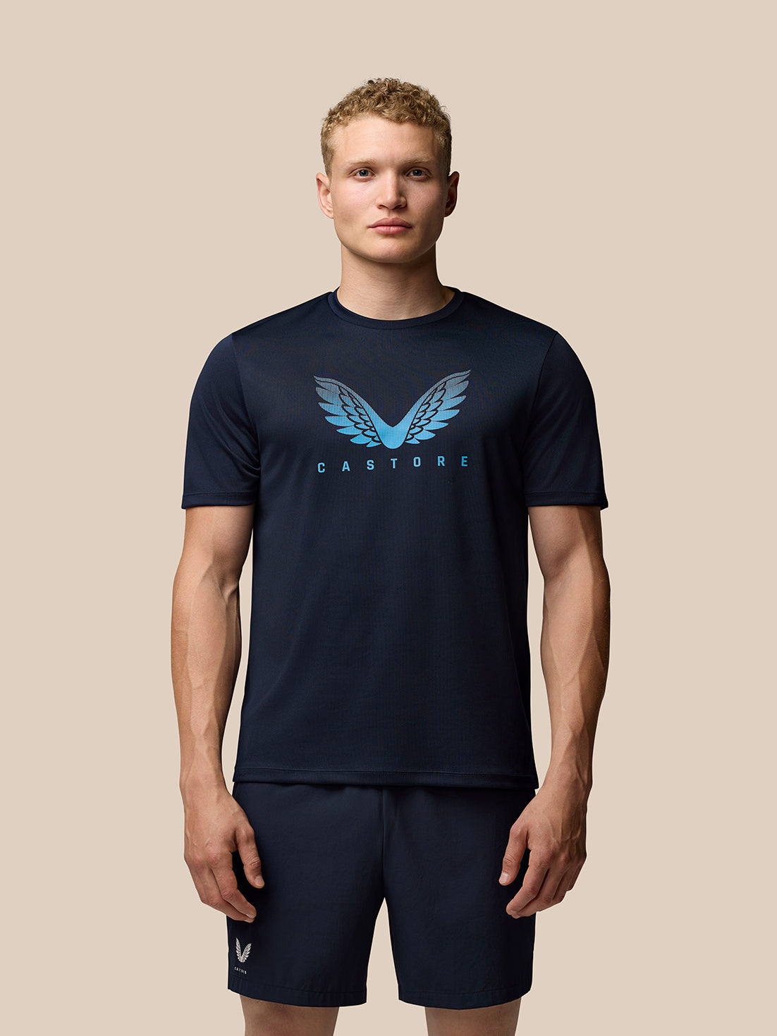 Male model wearing Adapt Training T-Shirt in Midnight Navy with a light blue Castore wing logo on the chest