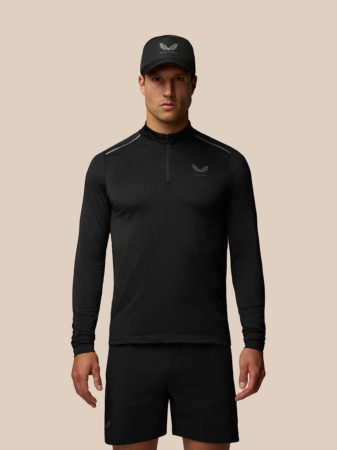 Male model wearing black Apex Training 1/4 Zip Top with stand collar and left chest logo