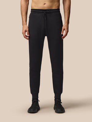 Male model in black Flex Lifestyle Joggers with drawstring waist and cuffed ankles; Castore branding on left thigh.