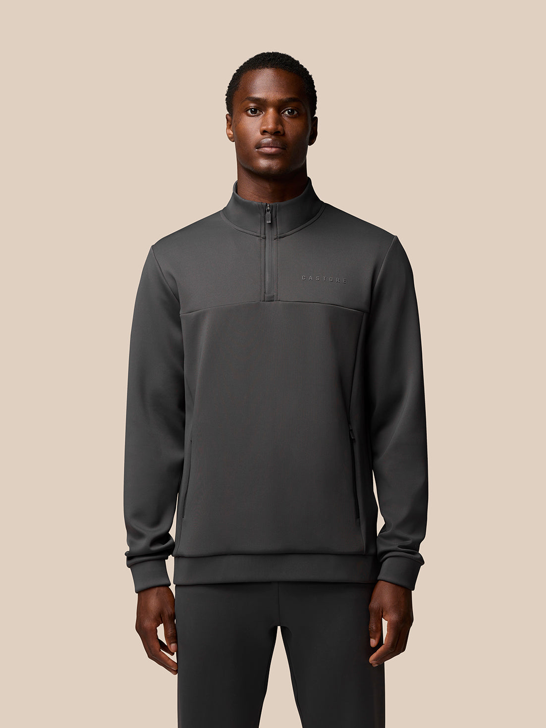 Male model wearing charcoal Flex Lifestyle 1/4 Zip top front view with chest branding
