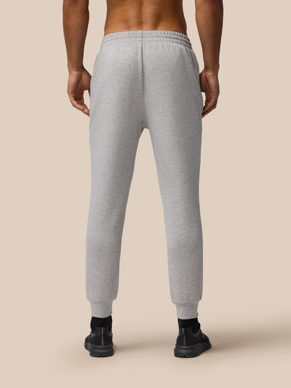 Back view of male model wearing grey marl Travel Lifestyle Joggers with a tapered fit, elastic waistband and cuffed hems