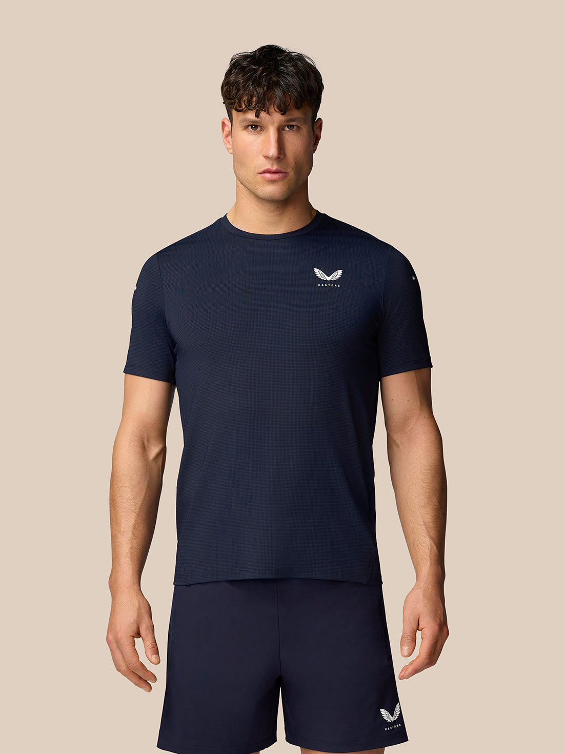 Male model wearing navy Apex Training T-Shirt with crew neck and white Castore logo on the chest, regular fit and short sleeves.