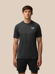 Flow Training T Shirt in black worn by a model front view with small chest logo and seamless knit texture