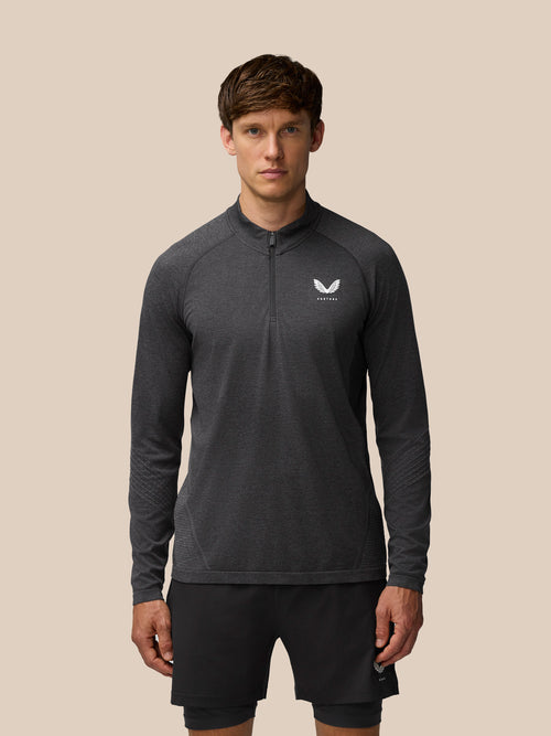 Front view of a model wearing Flow Training 1/4 Zip Top in black with chest branding
