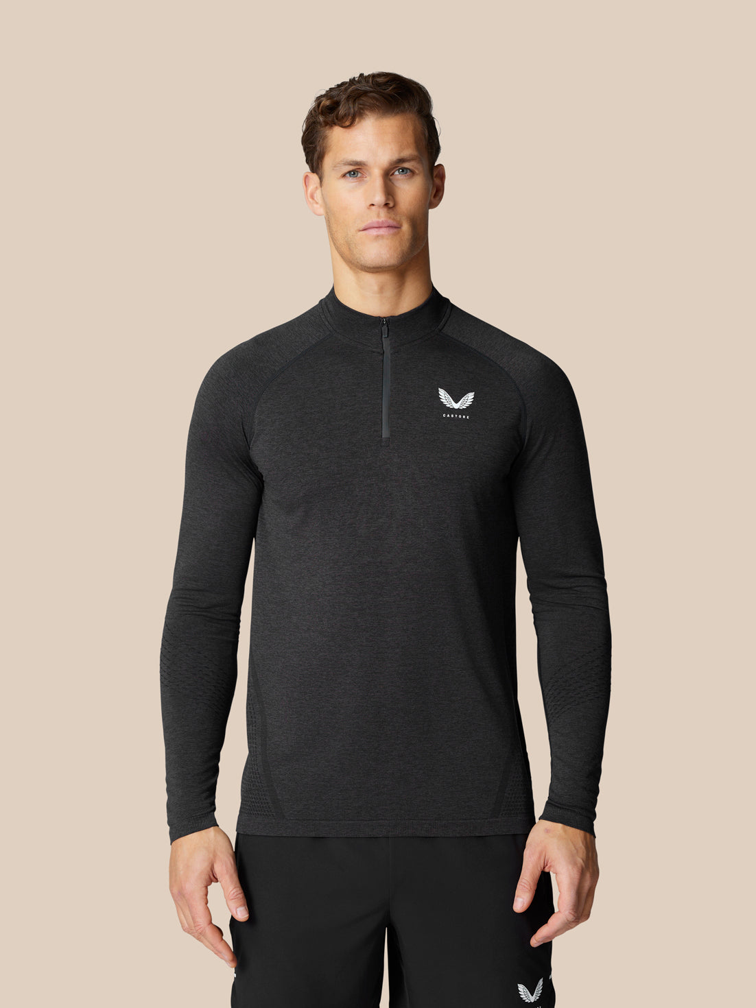 Model wears black Flow Training Top with quarter zip, seamless construction and breathable back panels.