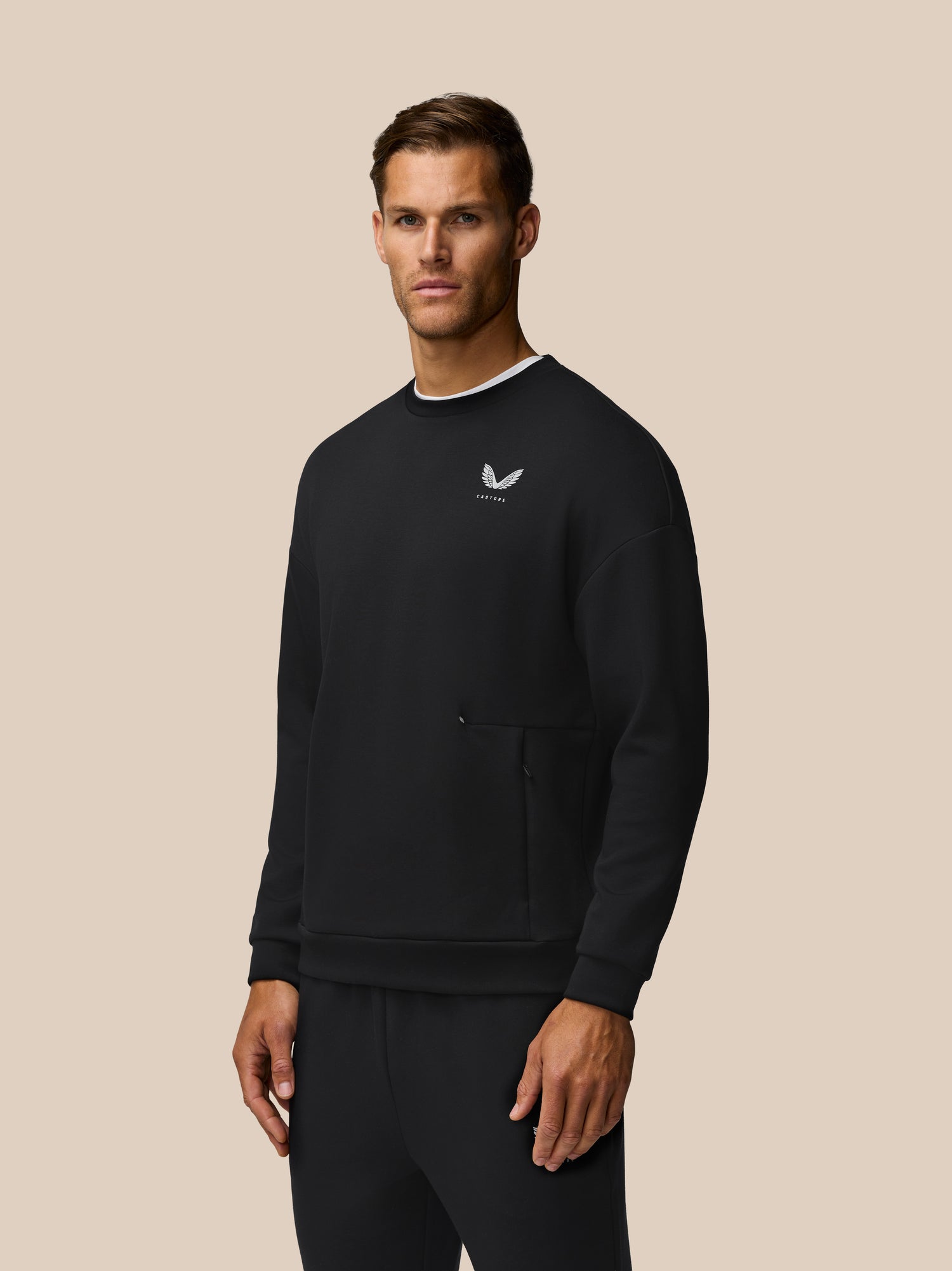 Front view of a man wearing black Travel Lifestyle Sweatshirt with a small white logo on the left chest.