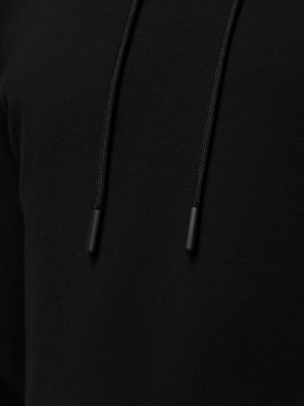 Close up of black Travel Lifestyle Hoodie fabric with drawstrings and tips.