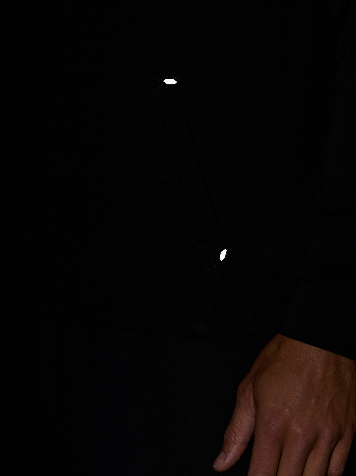 Close-up of the black Travel Lifestyle Hoodie front featuring drawstrings and reflective trim