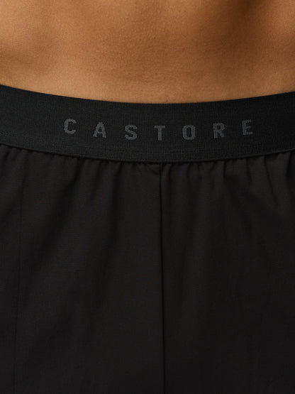 Black athletic shorts with 'Castore' branding on a brown background