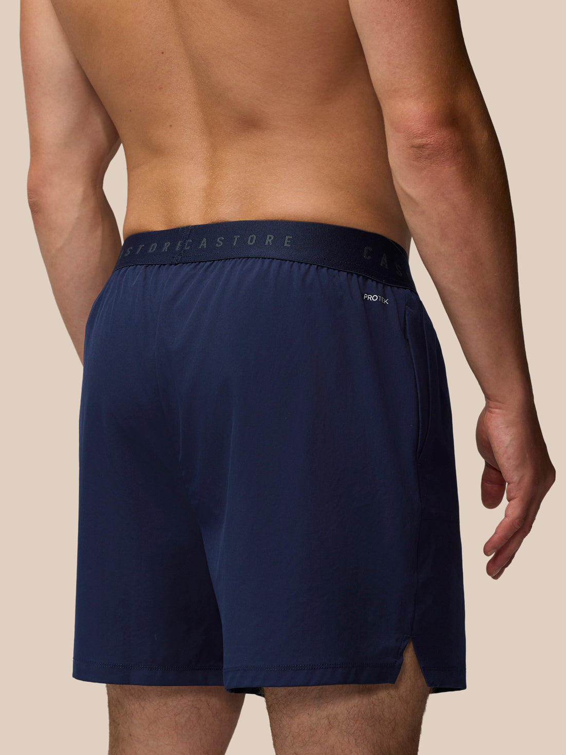 Navy blue boxer briefs with brand logo on a beige background