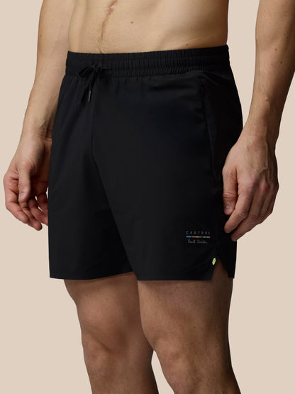 Black shorts worn by a person on a beige background