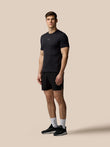 Man wearing a black t-shirt and shorts on a beige background