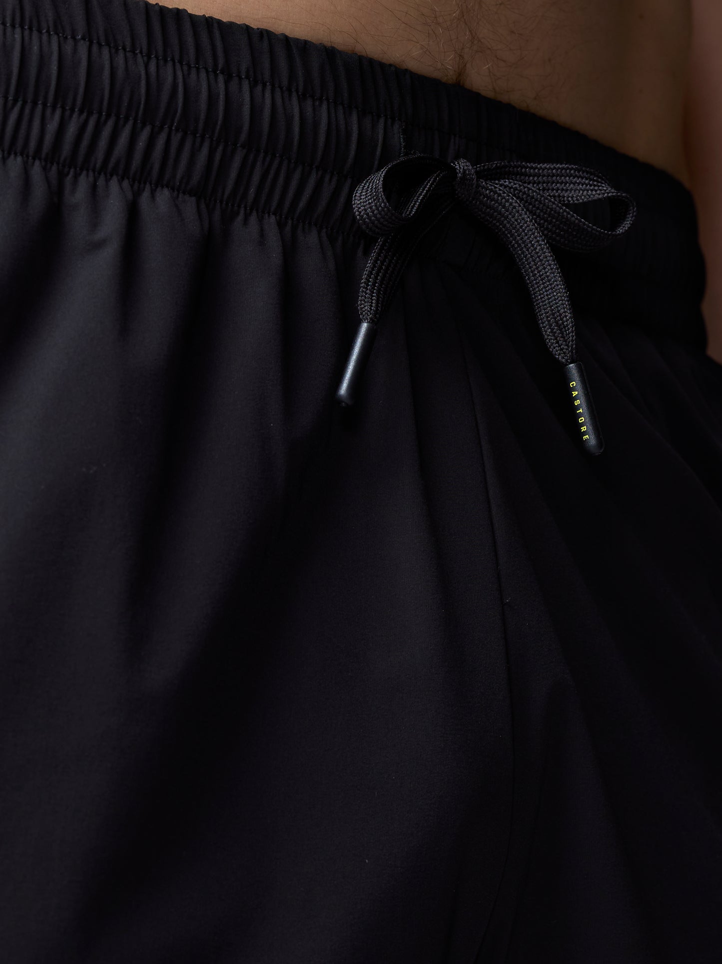 Black pants with a drawstring waistband on a neutral background