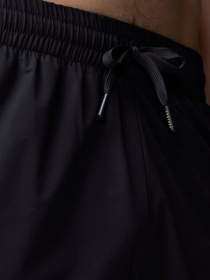 Black pants with a drawstring waistband on a neutral background