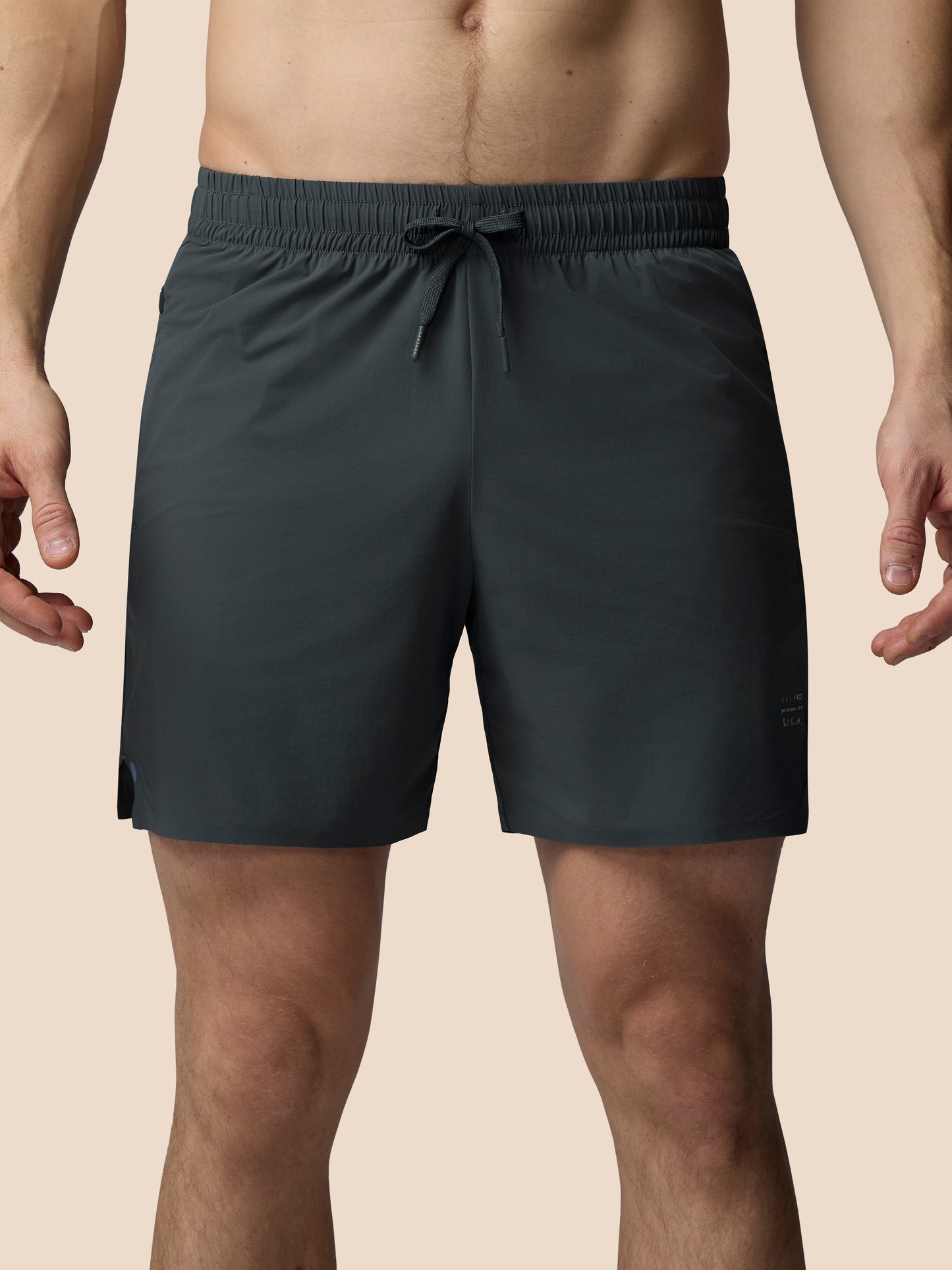 Dark gray shorts worn by a person on a beige background