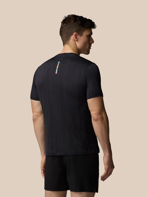 Man wearing a black athletic outfit on a beige background