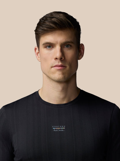 Man wearing a black t-shirt with a logo on a beige background