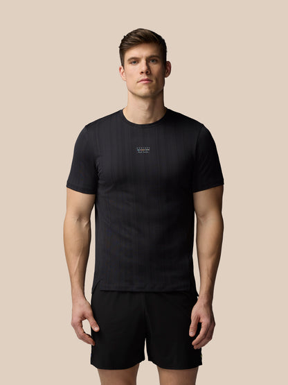 Man wearing a black t-shirt and shorts on a beige background
