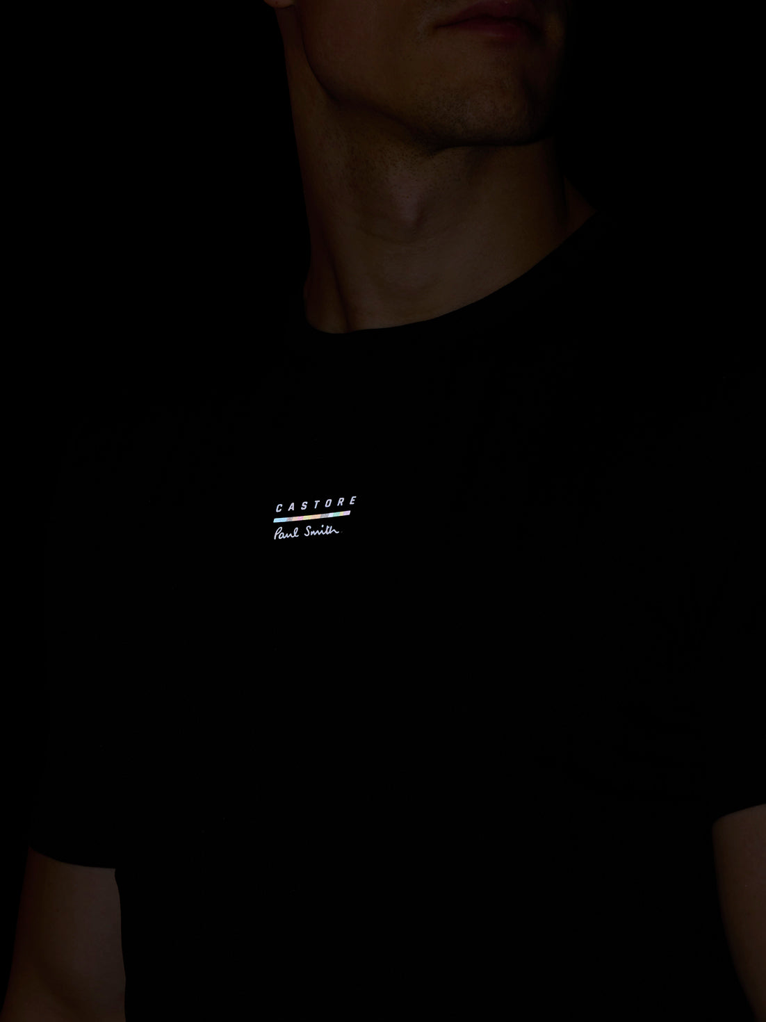 Black t-shirt with a small white logo on a dark background
