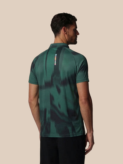 Man wearing a green camouflage-patterned polo shirt on a beige background