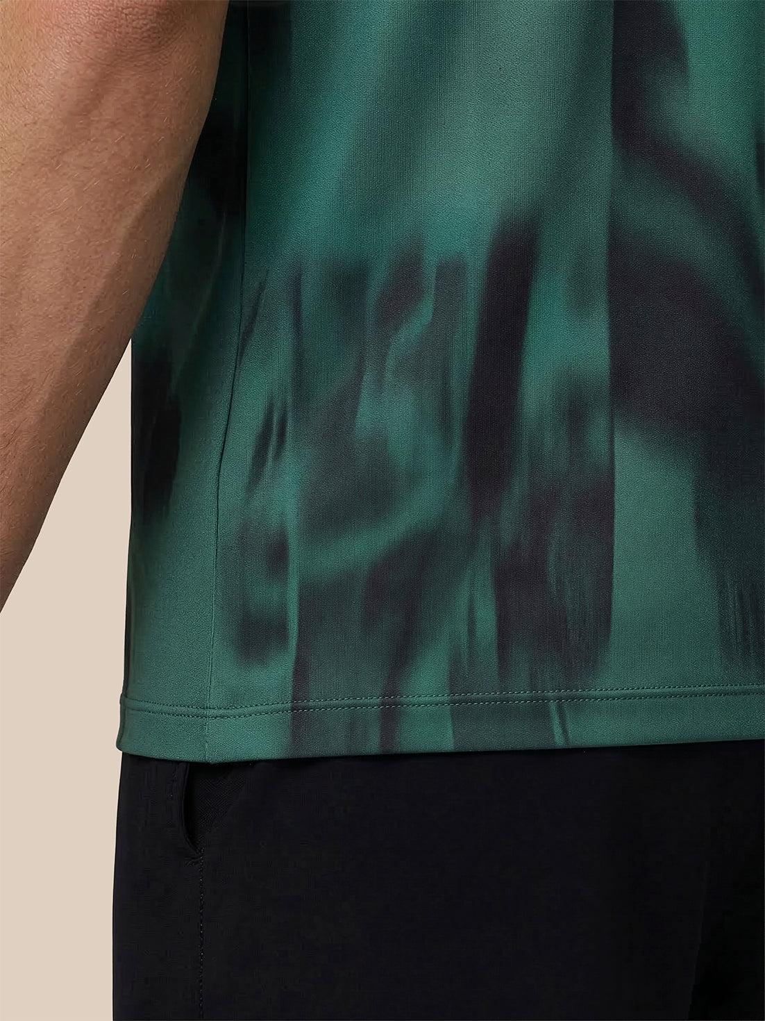 Close-up of a green camouflage-patterned shirt on a beige background