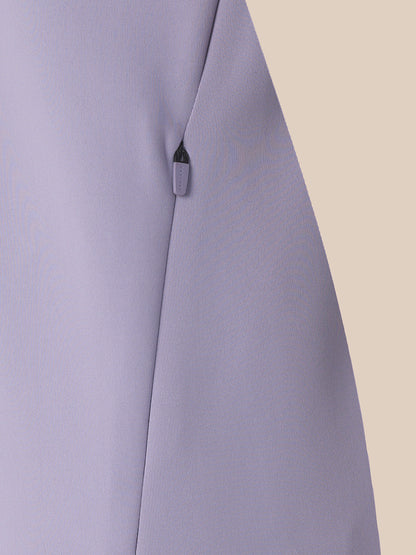 Close-up of a light lavender-gray fabric garment with a visible dark zipper pull on a plain beige background.