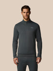 Man wearing a dark gray quarter-zip pullover with a visible brand logo on a beige background