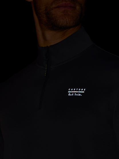 Close-up of a person wearing a dark jacket with a brand logo on a black background