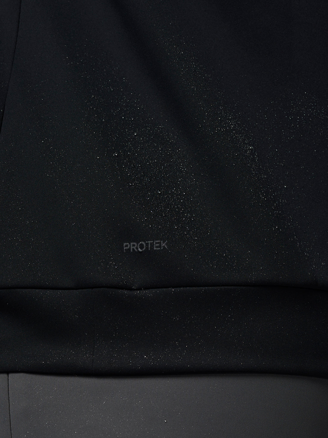 Black fabric with 'PROTEK' branding on a black background