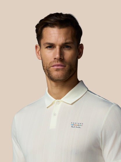 Man wearing a white polo shirt with brand logos on a beige background
