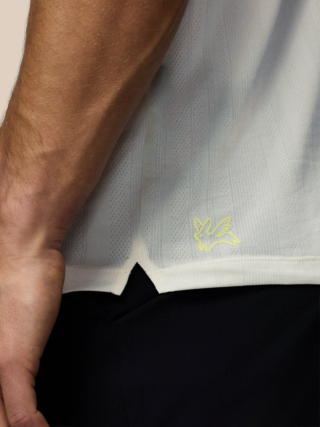 Close-up of a person wearing a white shirt with a yellow logo, focusing on the collar area.