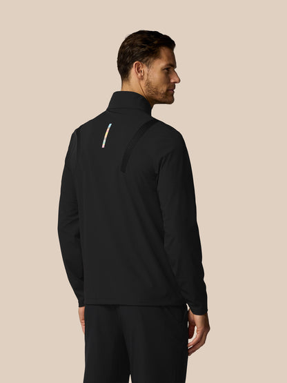 Man wearing a black jacket with a zipper on a beige background