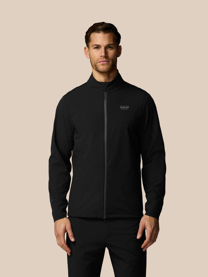 Man wearing a black jacket with a brand logo on a beige background