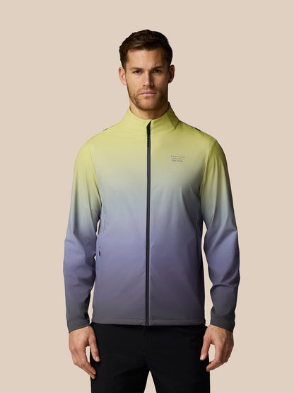 Man wearing a gradient jacket with a brand logo on a beige background