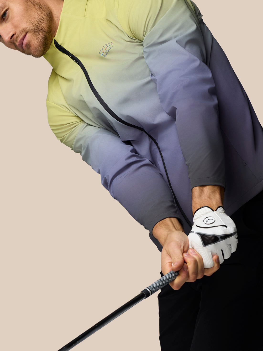 Person holding a golf club with a neutral background