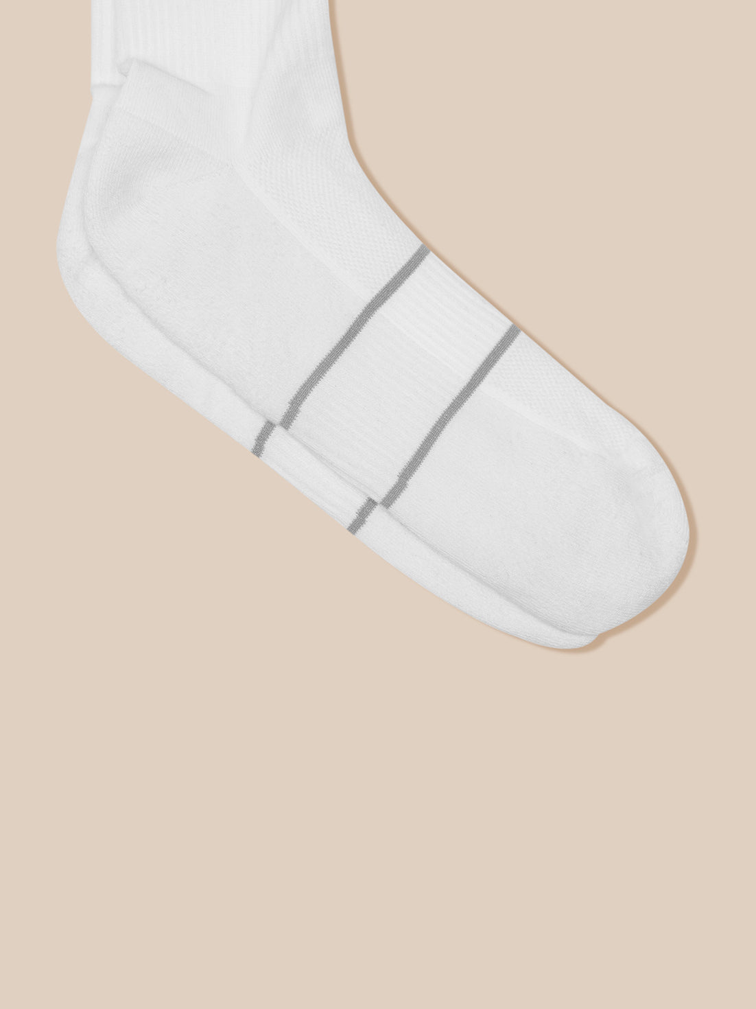 White crew sock with two small gray stripes near the toe against a beige background