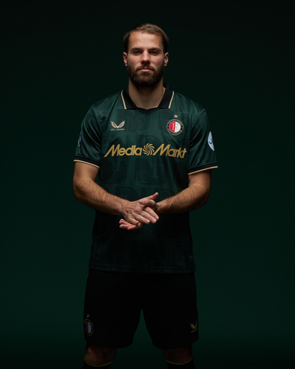 Male model wearing dark green Feyenoord football shirt with gold trim and crest, front view.