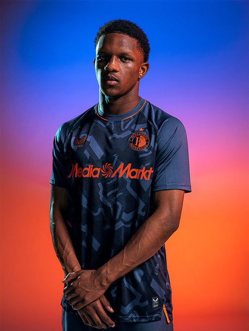 Male model wearing Feyenoord 2026-27 third pro shirt in navy with orange detailing and sponsor graphics