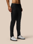 Male model in black golf trousers with ProTek water-repellent coating and side pockets; Castore logo on thigh.
