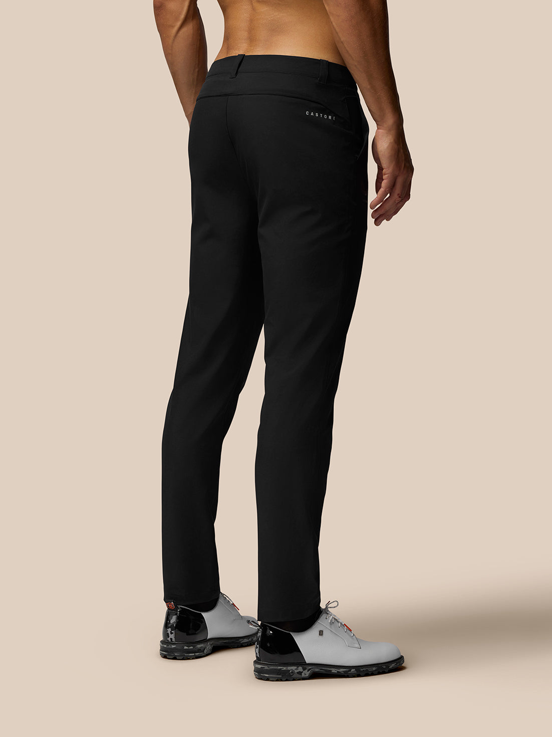 Back view of black Club Golf Trousers on a male model with a rear pocket and Castore branding at the right hip