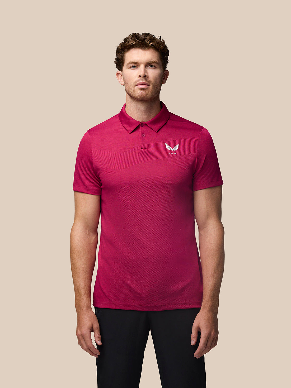 Man in pink Pinnacle golf polo with short sleeves and three-button placket, Castore logo on chest.