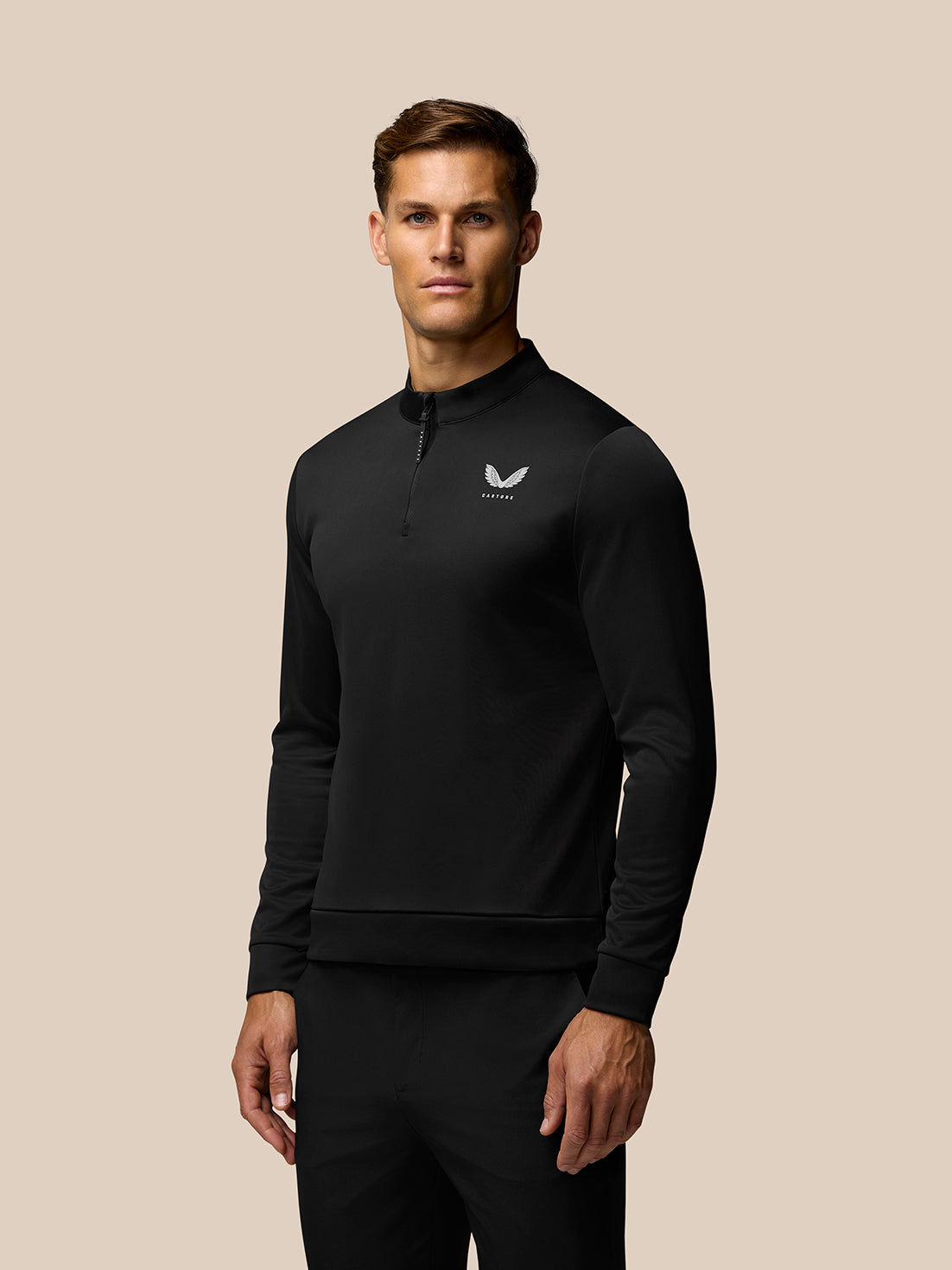 Male golfer wearing black Golf Club Classic 1/4 Zip Top with stand collar and chest branding.