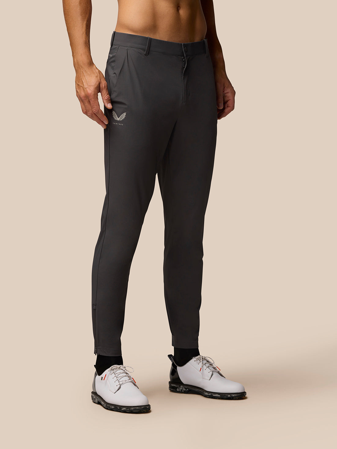 Charcoal golf joggers on a model, front view with open side pockets and Castore logo on the right thigh